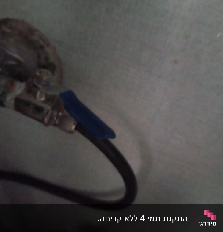 ברז עם ידית כחולה וצינור מתכת מחובר